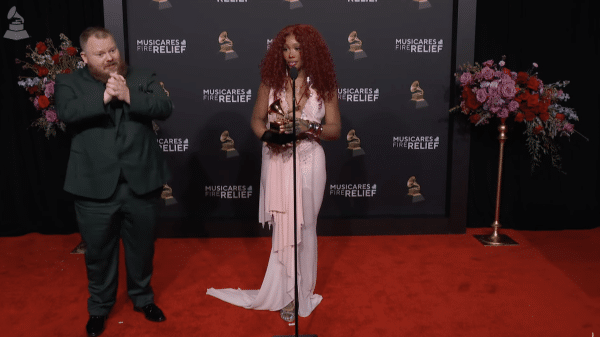SZA stands with interpreter as she answers questions at the Pre-Grammys